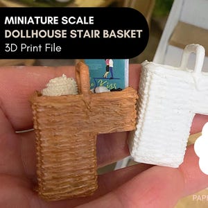 Può includere: Sono mostrati due cestini per scale di casa delle bambole in miniatura, uno marrone e uno bianco. Il cestino marrone ha un manico ed è riempito con un materiale bianco e soffice. Il cestino bianco è una stampa 3D. Il testo sull'immagine recita "MINIATURE SCALE DOLLHOUSE STAIR BASKET 3D Print File".