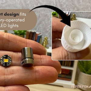 May include: Miniature LED lights and a white, textured container are displayed. The text reads "Smart design fits battery-operated mini LED lights." The lights are designed for miniature projects. The image shows the components of a miniature lighting system.