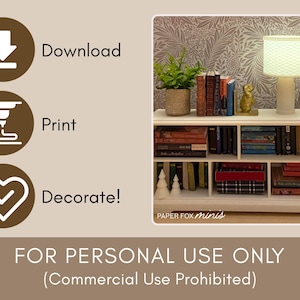 May include: A miniature white bookshelf filled with books, a lamp, and decorative items. The bookshelf has multiple shelves and is set against a patterned wallpaper. A small potted plant and a gold figurine are also visible.