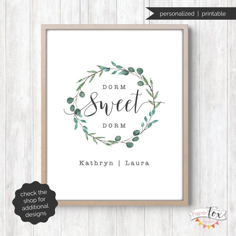 May include: A printable dorm room sign with a green leafy wreath and the text "DORM Sweet DORM" with the names Kathryn and Laura below.