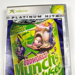 May include: Xbox video game case for Oddworld: Munch's Oddysee. The case is silver with a green and yellow can design featuring the game's title and a cartoon character. The ESRB rating is Teen.