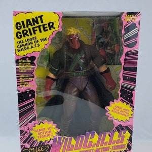 May include: A 10-inch action figure of Giant Grifter from the WildC.A.T.S. comic book series. The figure is wearing a black and green costume with a red mask and has a red cape. The figure is holding a gun in his right hand. The packaging is pink and black with the WildC.A.T.S. logo and the words "Giant Grifter" and "The Loose Cannon of the WildC.A.T.S."