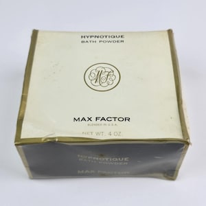 Può includere: Scatola vintage di polvere da bagno Hypnotique di Max Factor. La scatola bianco sporco ha finiture dorate e il testo "HYPNOTIQUE BATH POWDER" e "MAX FACTOR". Il peso netto è di 113 grammi. La scatola presenta un emblema circolare con le lettere "MF".