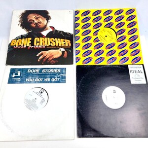 May include: Four vinyl records with white labels. The top left record has a black and white photo of a man with the text "BONE CRUSHER WASSA FRIPPIN'" on the cover. The top right record has a yellow cover with a repeating pattern of the text "WHAT'S UP" in red. The bottom left record has a white cover with the text "DOPE STORIES YOU GOT WE GOT". The bottom right record has a black cover with the text "IDEAL" in white.