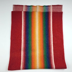 May include: A red and white striped blanket with a colorful rainbow stripe in the center.