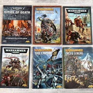 May include: Six Warhammer 40,000 books with various covers. Titles include "Cities of Death", "Orcs & Goblins", "Tau Empire", "Tyranids", and "The Empire". The books feature illustrations of battles and characters from the Warhammer universe.