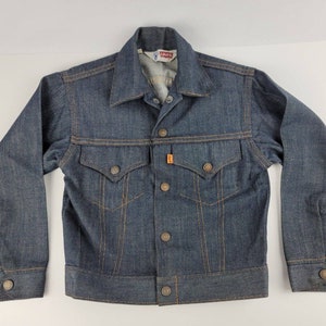 May include: A blue denim jacket with a button closure, two front pockets, and a Levi's label on the pocket.