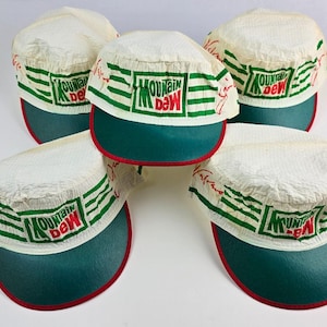 Puede incluir: Cinco gorras visera blancas y verdes de Mountain Dew con visera verde y ribete rojo. Las gorras tienen el logotipo de Mountain Dew en verde y rojo, con rayas verdes. Las gorras están hechas de un material texturizado.