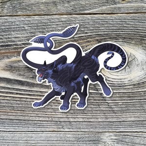 May include: A black and blue creature with a long, curled tail and a fierce expression. The creature has a furry body and a long, pointed snout.