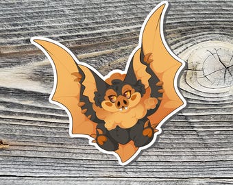 May include: A cute orange and black bat with large eyes and a fluffy body. The bat is depicted with its wings spread out.
