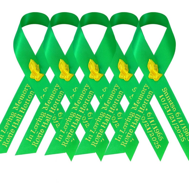 May include: Five bright green satin ribbons arranged in a row, each featuring a gold-colored praying hands emblem. The ribbons are printed with the text In Loving Memory, Rome Hall Horton, and the dates 6/1/1965 and 10/21/2025 in gold lettering.