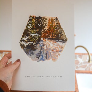 May include: A watercolor painting of a snowy forest path with warm sunlight filtering through the trees. The text "A winter breeze met warm sunlight" is printed below the image.