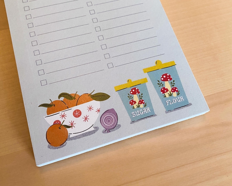 May include: A blue and white notepad with a checklist and a decorative illustration of a bowl of oranges, an onion, and two blue and white canisters labelled "Sugar" and "Flour".