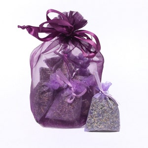 Purple organza bag filled with small lavender drawer sachets, one single lavender drawer sachet shown outside bag.