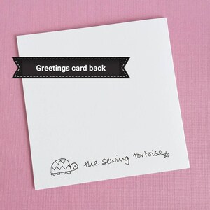 May include: The back of a white greeting card with a black and white illustration of a turtle and the text "the sewing tortoise".
