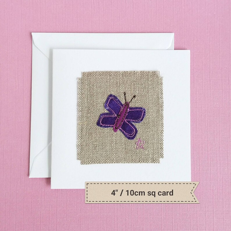 May include: A handmade card with a purple butterfly embroidered on a beige linen fabric. The card is 4 inches square.