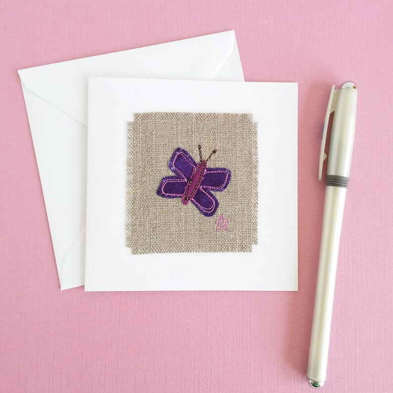 May include: A handmade greeting card with a purple butterfly embroidered on a piece of burlap fabric.