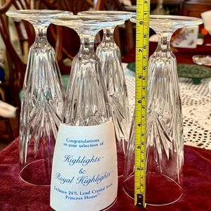 Peut inclure: Quatre fl&ucirc;tes &agrave; champagne en cristal transparent, chacune avec un dessus plat et un design textur&eacute; &agrave; facettes. Les fl&ucirc;tes mesurent environ 20 cm de haut. Une &eacute;tiquette indique "Highlights & Royal Highlights" et "Exclusive 24% Lead Crystal from Princess House."
