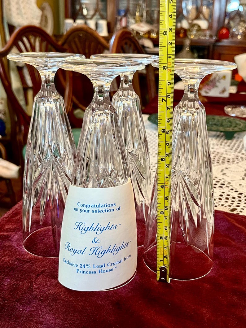 Peut inclure: Quatre fl&ucirc;tes &agrave; champagne en cristal transparent, chacune avec un dessus plat et un design textur&eacute; &agrave; facettes. Les fl&ucirc;tes mesurent environ 20 cm de haut. Une &eacute;tiquette indique "Highlights & Royal Highlights" et "Exclusive 24% Lead Crystal from Princess House."