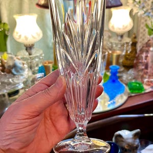 Peut inclure: Un fl&ucirc;te &agrave; champagne en cristal transparent avec un motif grav&eacute; d&eacute;taill&eacute;. Le verre a une longue tige et une base large et circulaire. Le motif grav&eacute; pr&eacute;sente des lignes verticales et des formes de feuilles, cr&eacute;ant un aspect textur&eacute;.