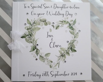 May include: A white card with a green leafy heart design and the text "To a Special Son & Daughter-in-law On your Wedding Day" and "Ian & Clare" and "Friday 27th September 2024".