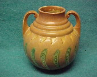 May include: A brown ceramic vase with two handles and a green and yellow floral design.