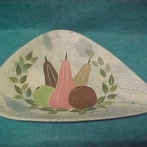May include: A white ceramic triangular serving dish with a painted design of pears and a green apple. The pears are pink, brown, and green. The dish has a textured surface.