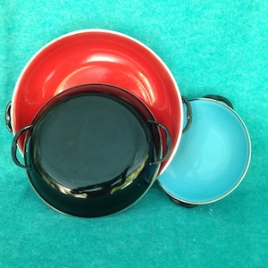 May include: Three nesting bowls, one red, one black, and one blue. The bowls are made of enamel and have a white rim.