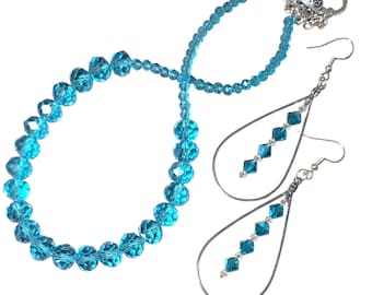 May include: A turquoise beaded necklace and matching earrings set. The necklace features large, faceted beads, while the earrings have a teardrop design with smaller, matching beads. The set includes a silver-toned clasp with an owl charm.