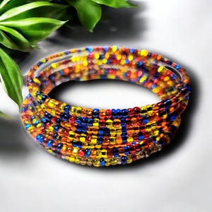 May include: Multicolored beaded bracelet with a mix of red, orange, yellow, and blue beads. The bracelet is made of small, round beads that are strung together in a tight pattern.