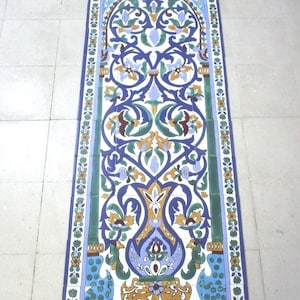 May include: A long, rectangular rug with a blue, green, and yellow floral pattern. The rug is made of ceramic tiles and has a traditional Moroccan design.