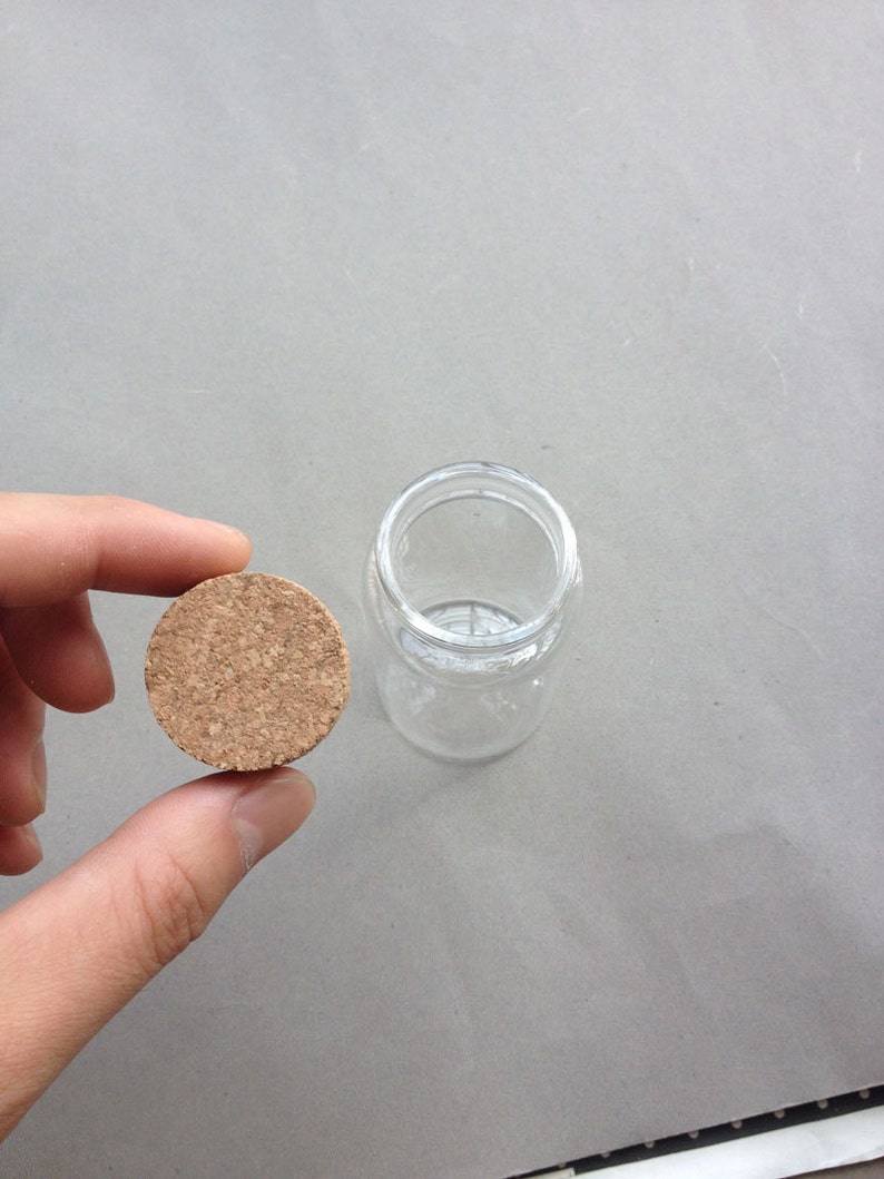 May include: A round, brown cork stopper for a glass bottle.