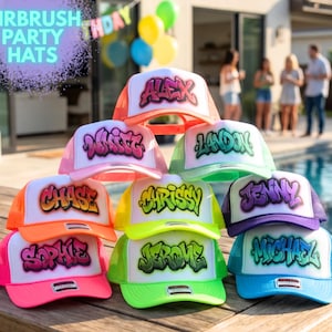 May include: A collection of airbrush party hats in various colors, stacked on a wooden table. Each hat features a different name in graffiti-style lettering. The hats have white fronts and colored mesh backs, with the text "AIRBRUSH PARTY HATS" in a purple bubble.