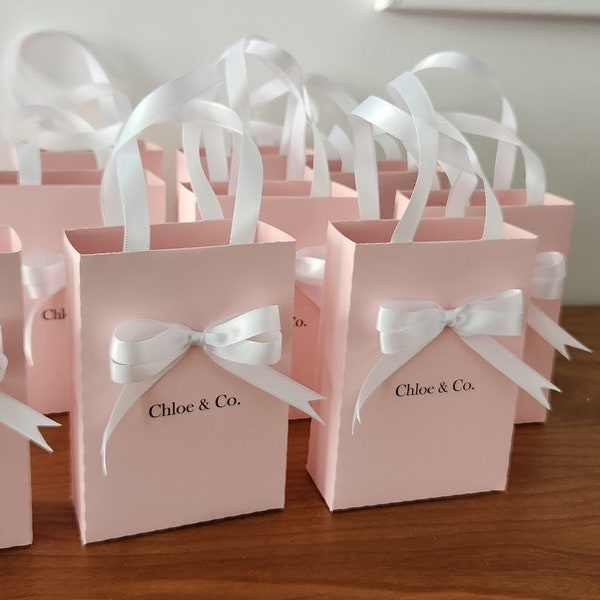 Favor bags. Elegant Bags for guests with satin ribbon handles and custom name