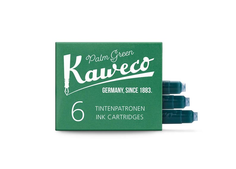 Pu&ograve; includere: Una scatola verde di cartucce d'inchiostro Kaweco Palm Green. La scatola ha un testo bianco che recita "Palm Green Kaweco GERMANY, SINCE 1883." e "6 TINTENPATRONEN INK CARTRIDGES." Sono visibili tre cartucce d'inchiostro.