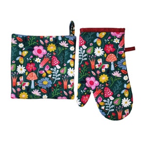 May include: A dark green oven mitt and pot holder set with a colourful floral and mushroom pattern. The design includes pink, white, and yellow flowers, butterflies, and red mushrooms. The pot holder has a hanging loop.