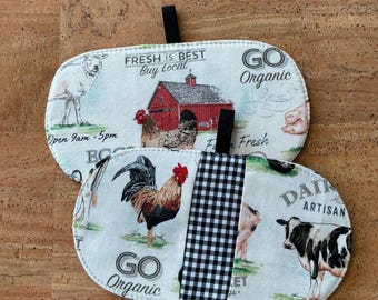 May include: Two oval-shaped fabric pot holders with black hanging loops. One features a farm scene with a red barn, chickens, and the text "FRESH IS BEST Buy Local." The other has a rooster, cow, pig, and the text "GO Organic."