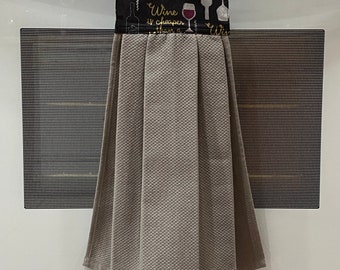 May include: A hanging kitchen towel with a black top featuring wine-themed graphics and the phrase "Wine is cheaper than a therapist." The towel is gray with a textured pattern and hangs from a buttoned loop.