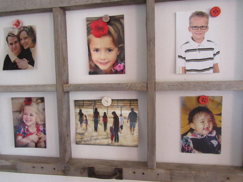 May include: A rustic wooden frame displaying six photographs, each held in place by decorative buttons. The photos feature portraits of people and family scenes, creating a personalized and charming display.