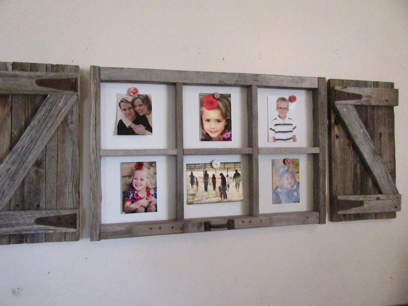 May include: A rustic wooden picture frame with six photo openings, flanked by two wooden shutters. The frame holds various photos, secured with decorative pins. The wood has a weathered, gray appearance, adding a vintage aesthetic.