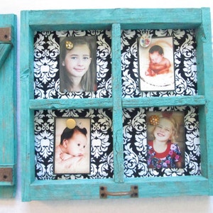 May include: A turquoise wooden picture frame with four photo slots. Each slot holds a photograph, secured with decorative pins. The background is a black and white damask pattern. The frame has a rustic, distressed finish.