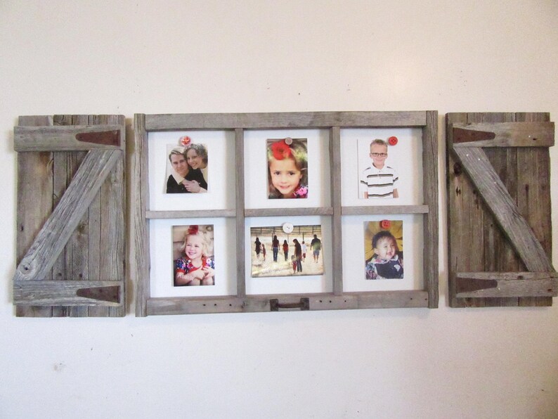 May include: A rustic wooden picture frame with six photo openings and two matching wooden shutter-style side panels. The frame holds various family photos. The wood has a weathered, gray appearance, with visible grain and metal hinges.