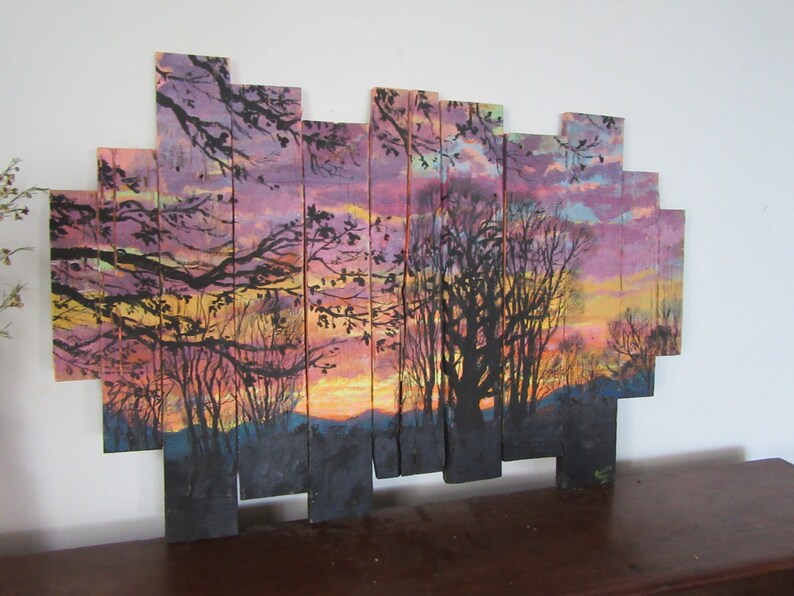 May include: A sunset scene painted on wooden planks, with a silhouette of trees and a purple, pink, and orange sky.