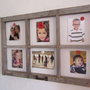 May include: A rustic, wooden picture frame with six openings, each holding a photograph. The frame is made of weathered gray wood and has a grid-like design. Photos are secured with decorative buttons. The photos feature people of different ages.