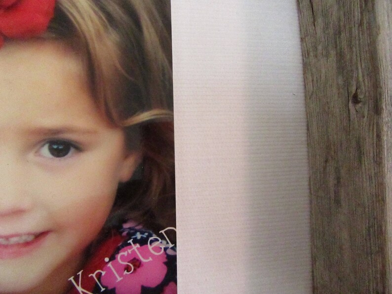 May include: A portrait of a young girl with blonde hair and a red bow. The girl is wearing a pink and black floral top. The name "Kristen" is printed in a cursive font on the bottom of the image.