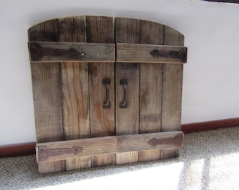May include: A pair of rustic wooden doors with arched tops and metal hinges. The doors are made of reclaimed wood and have a weathered finish.