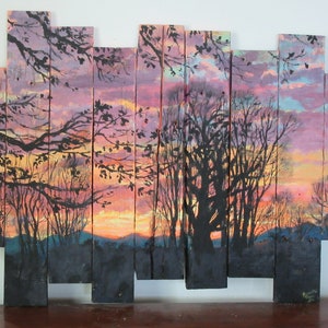 May include: A sunset scene painted on wooden planks. The painting features a silhouette of trees against a pink, orange, and yellow sky. The planks are arranged in a staggered pattern.