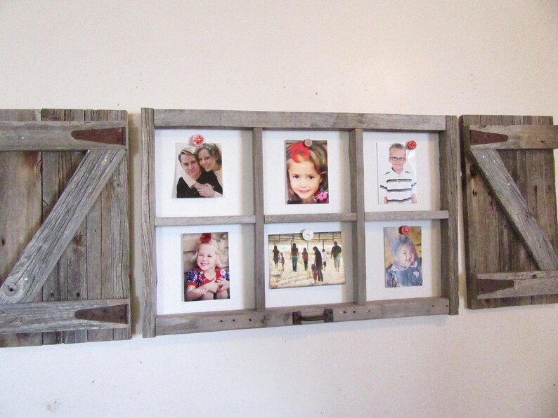 May include: A rustic wooden picture frame with six photo openings, flanked by two wooden shutter-style panels. The frame holds various photos, and the shutters have metal hinges and diagonal wooden supports. The overall design is a farmhouse style.