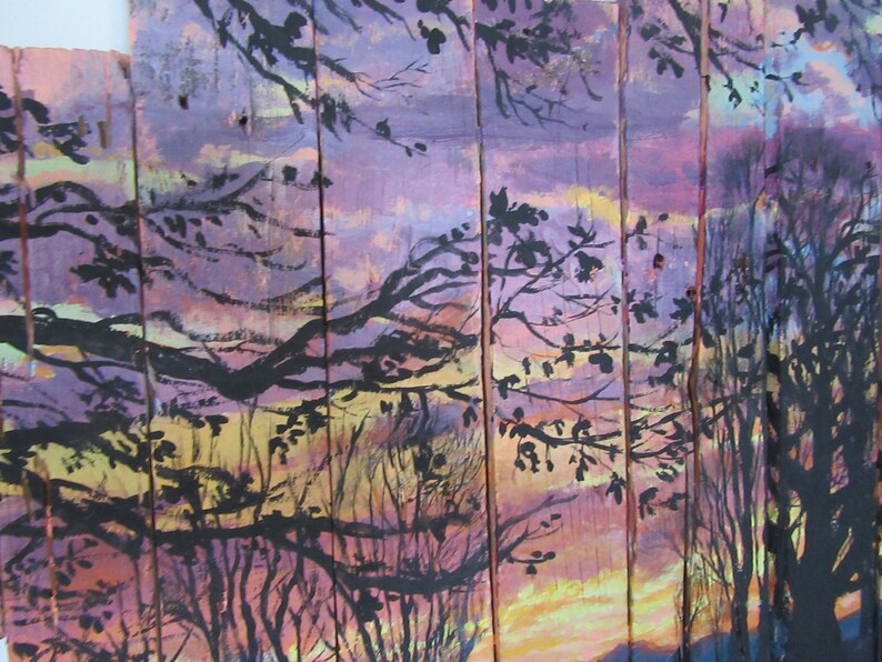 May include: A painting on wood panels depicting a sunset scene with silhouetted trees. The sky is painted in shades of purple, pink, and yellow, with a hint of orange at the horizon. The trees are black and create a dramatic contrast against the colorful sky.