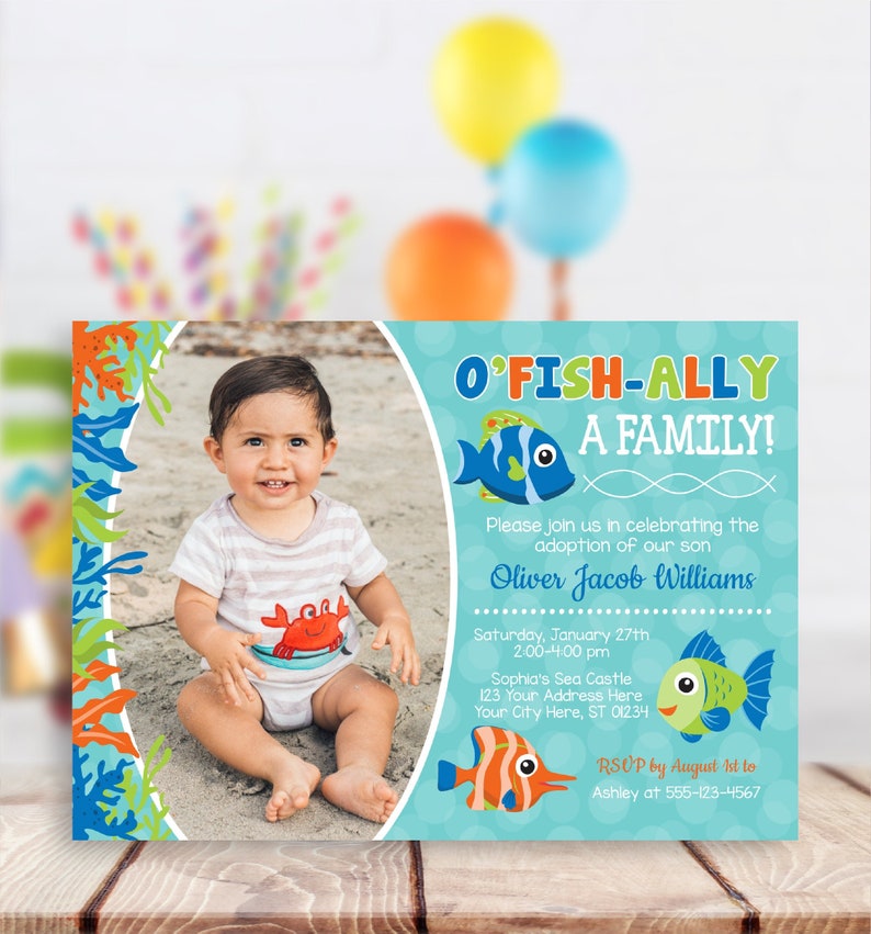 May include: A blue and green invitation card with a picture of a baby boy in a red and white crab onesie. The card says "O'Fish-Ally A Family!" and has a fish design. The text on the card says "Please join us in celebrating the adoption of our son Oliver Jacob Williams Saturday, January 27th 2:00-4:00 pm Sophia's Sea Castle 123 Your Address Here Your City Here, ST 01234 RSVP by August 1st to Ashley at 555-123-4567"